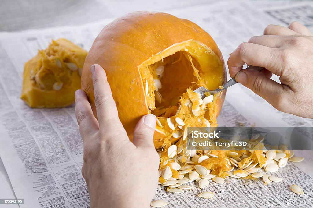 Pumpkin Carving for Halloween Hands scooping out the seeds and pulp before carving the jack o'lantern. Pumpkin Stock Photo