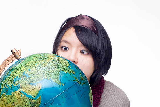 Conceptual image of a hand holding a magnifying glass over an world globe