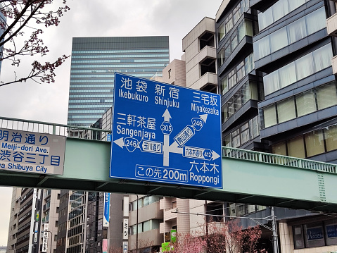 Directional sign hanging on a footbridge in Shibuya, Tokyo, Japan. I
