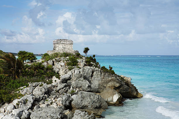 View of the ancient Tulum ruins in Mexico, overlooking the Caribbean Sea, showcasing Mayan architecture, historic walls, and tropical scenery