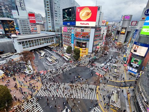 High angle view of the crowded Shibuya Crossing, a popular pedestrian scramble crossing in Shibuya, Tokyo, Japan. It is located in front of the Shibuya Station Hachikō exit and is the world’s busiest pedestrian crossing, with as many as 3,000 people crossing at a time.