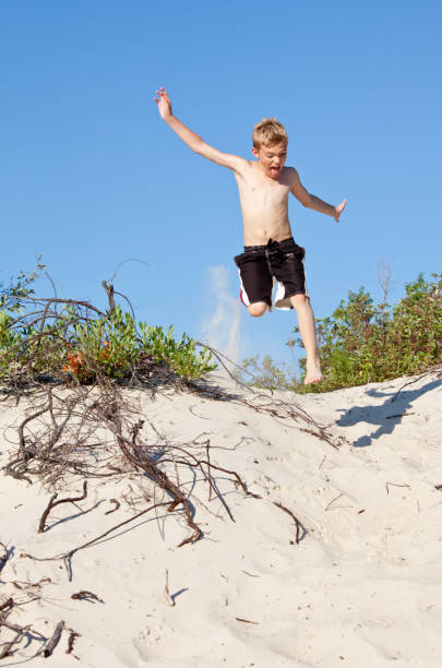 istock Young Boy Jumping on Sand Dunes at the Beach 172397052