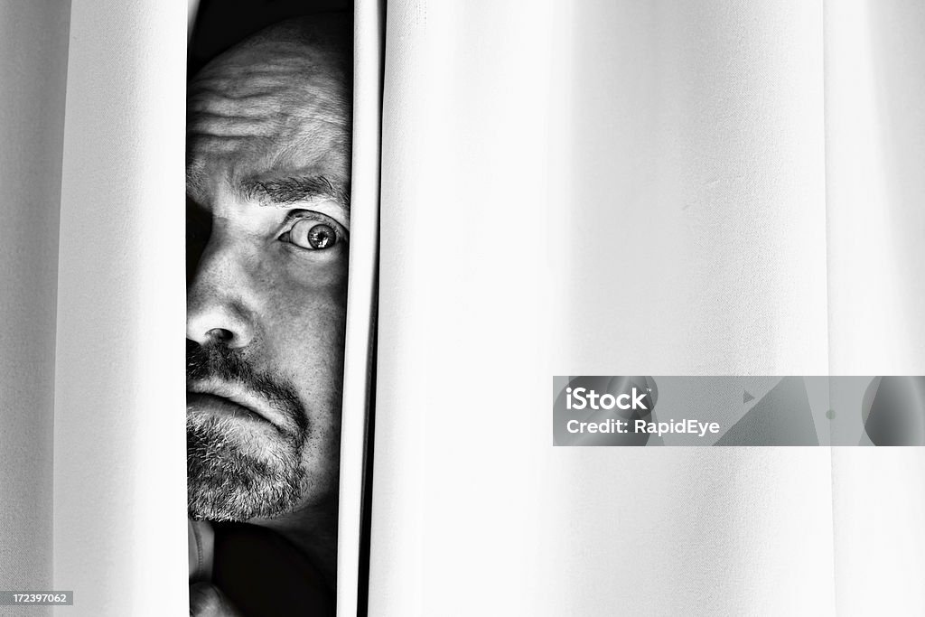 Aterrorizado, Fazer Caretas homem peeps fora da atrás das cortinas - Royalty-free Adulto Foto de stock