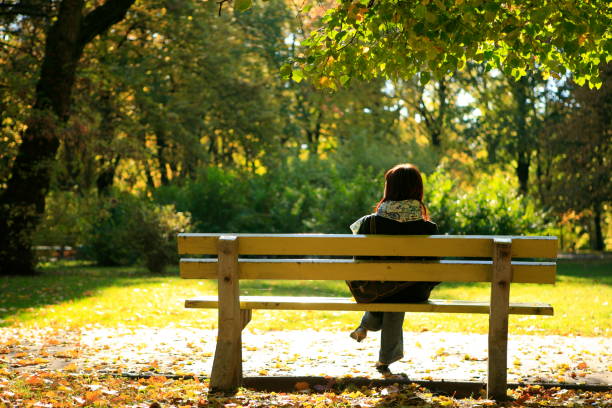 herbst-park-landschaft mit allein mädchen sitzt - gradiation stock-fotos und bilder