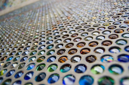 a metal grate filled with coloured marbles