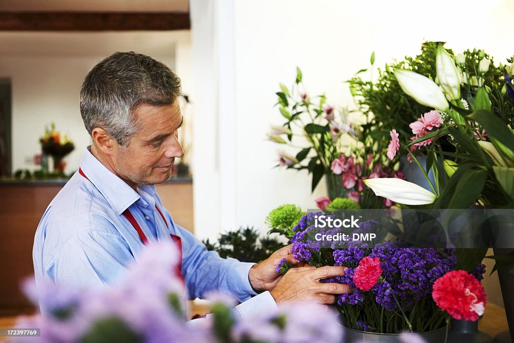 Uomo maturo che lavora in fiorista negozio - Foto stock royalty-free di Adulto
