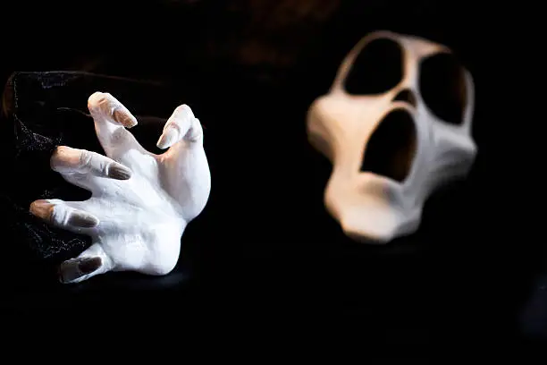 a white hand with screaming skull in background