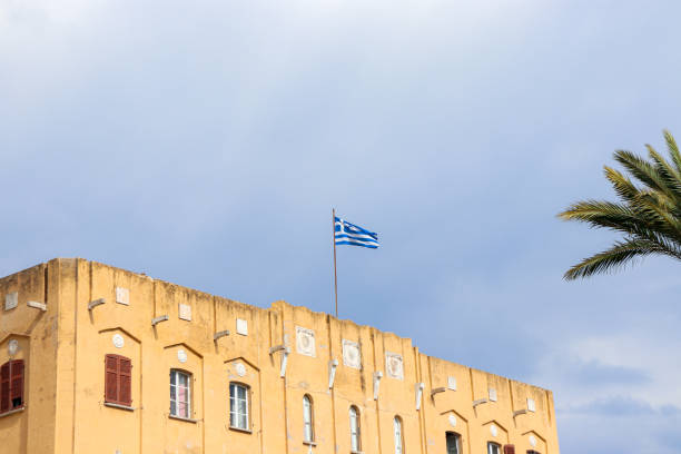 istock Greece national flag on top a building 1723983831