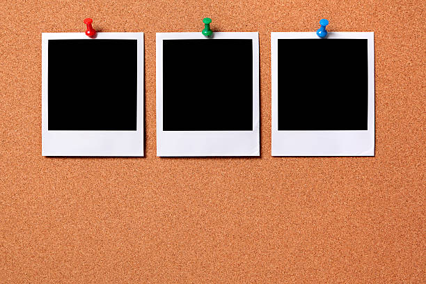 istock Three blank photos pinned to a cork board 172398887
