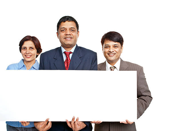 alegre seguro de indian negocios equipo con cartel - cheering business three people teamwork fotografías e imágenes de stock