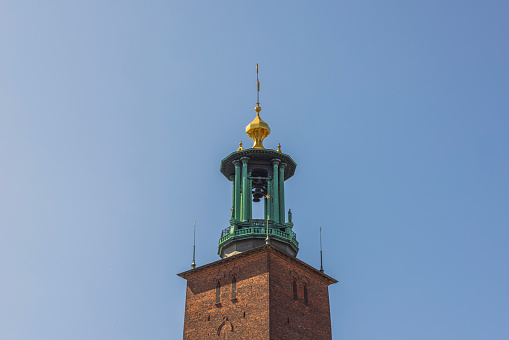 Close-up view of cathedral dome with bells on blue sky background.