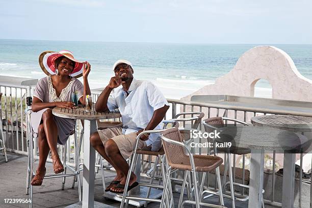 Foto de Casais Apreciando Drinques Na Praia Terraço e mais fotos de stock de Restaurante - Restaurante, Praia, Casal Jovem