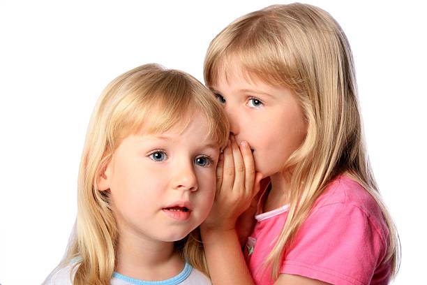 istock Two little girls whispering secrets on white background 172400214
