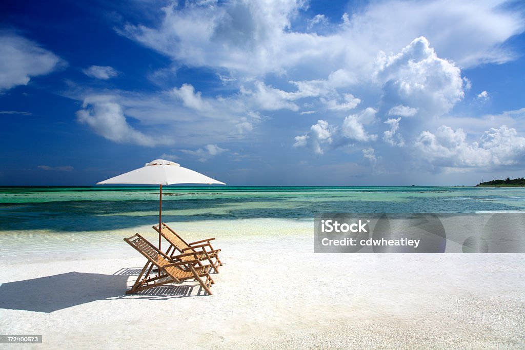 empy sillas de bambú y sombrilla en la arena en Florida - Foto de stock de Playa libre de derechos