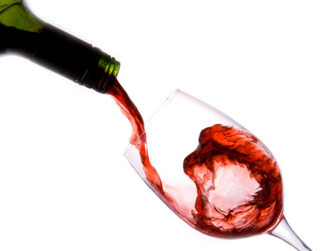 glass and red wine with white background in high speed