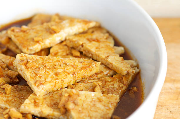 tempeh marinating con ajo y el jengibre en placa blanca - tempeh fotografías e imágenes de stock