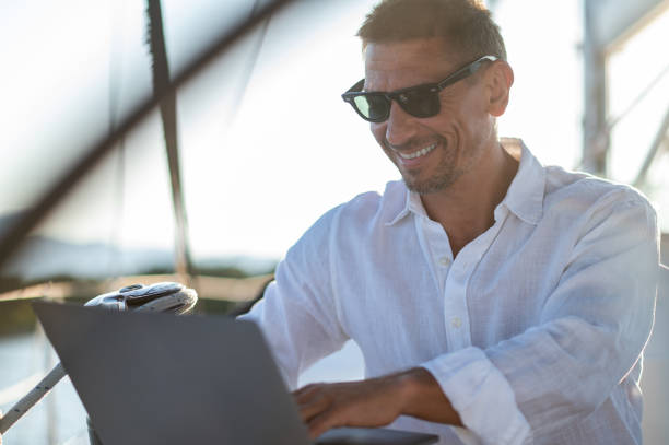 istock Successful mature man with a laptop working on a yacht 1724016601