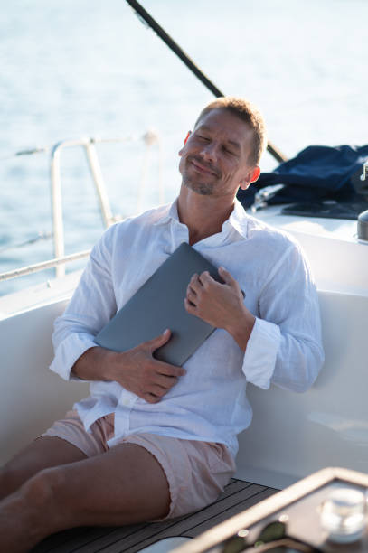 istock Successful mature man with a laptop working on a yacht 1724016625