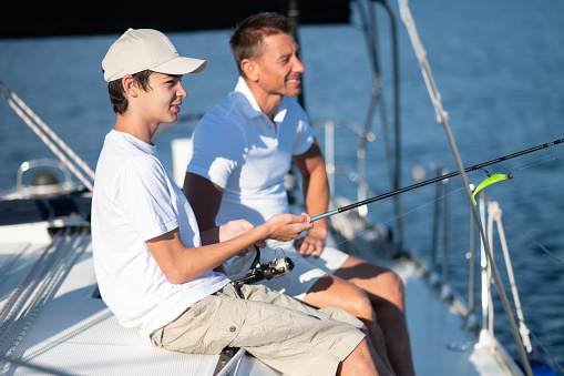 Fishing. Dad and son spending time together on the yacht and fisihing
