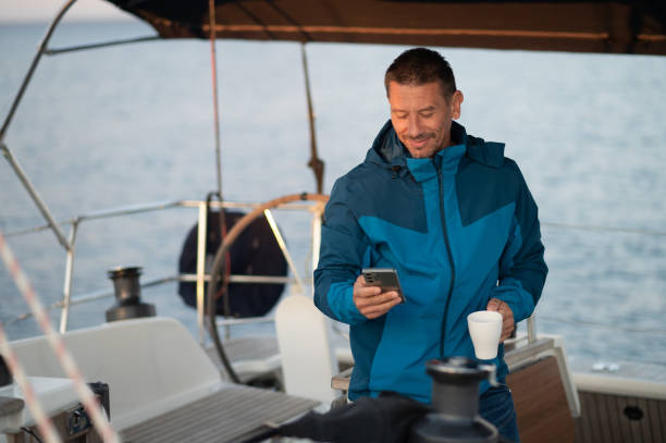 istock Man in blue jacket on the yacht having coffee and looking contented 1724017228