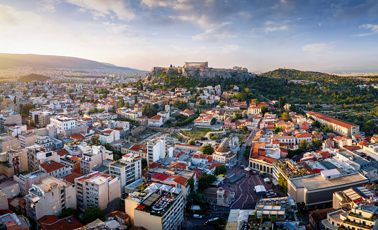 Panoramic view of the old town of Athens with Monastiraki square and the Parthenon Temple of the Acropolis during a golden sunrise