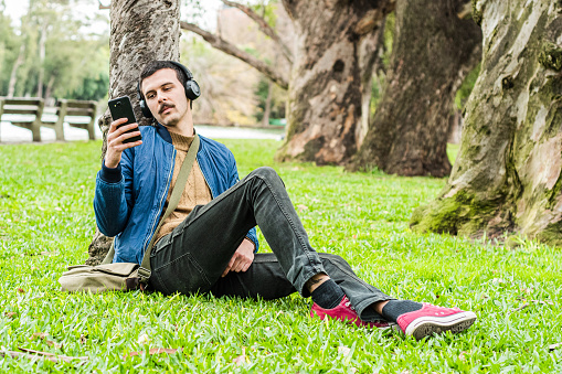 Young man using mobile phone on the public park