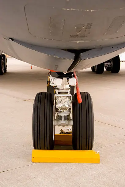 An underbelly shot of the nosewheel of a military transport plane.
