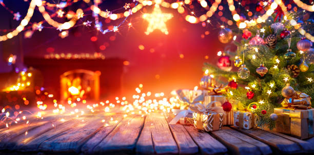 istock Present Below Christmas Tree With Garlands In Home Interior With Fireplace And Star - Abstract Defocused Lights 1724033812