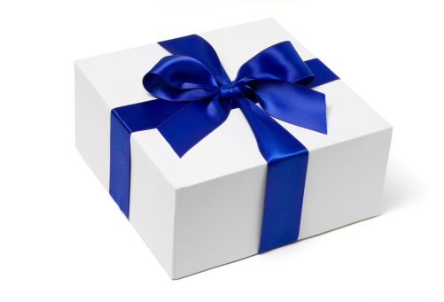 A white gift box tied with a blue satin ribbon bow.  Isolated on white with clipping path.
