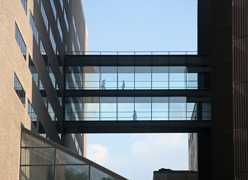 Silhouette of People walking on a bridge between two buildings, Mount Sinai Medical Center, New York City, NY, USA.