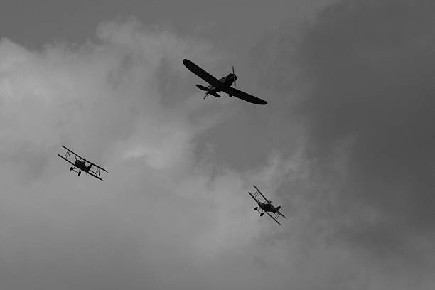 WWI Dogfight WWi dogfight with a German monoplane being chased by two English biplanes. airshow photos stock pictures, royalty-free photos & images