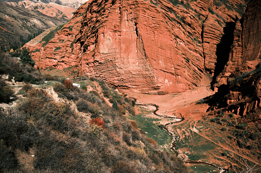 Curved river flowing between red rocks in autumn