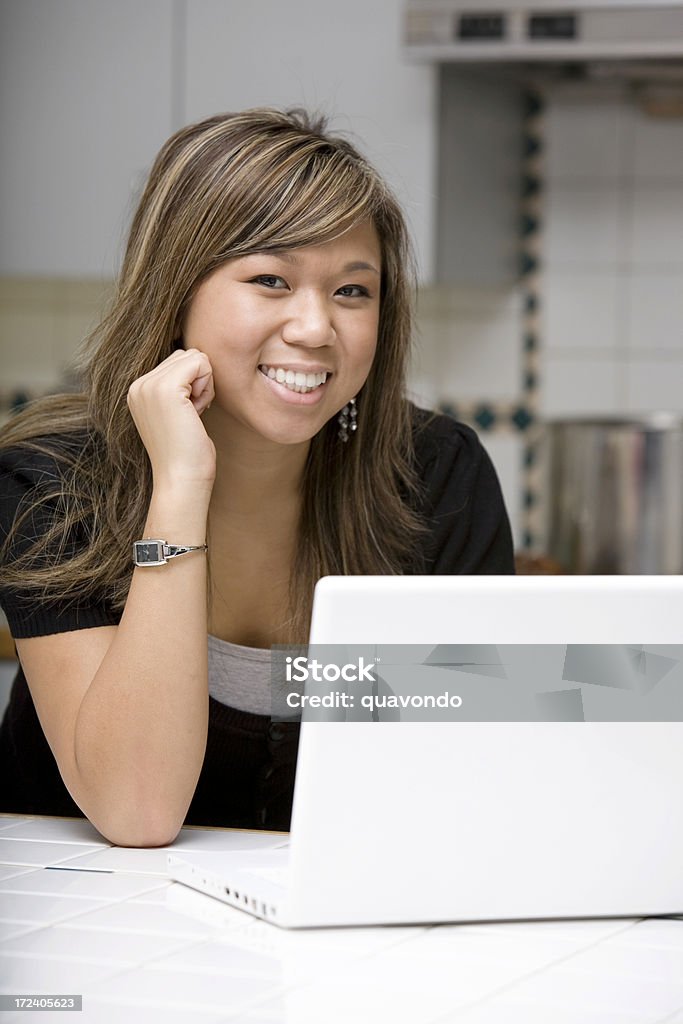 Jeune femme asiatique à l'aide d'un ordinateur portable dans la cuisine, espace de copie - Photo de 16-17 ans libre de droits