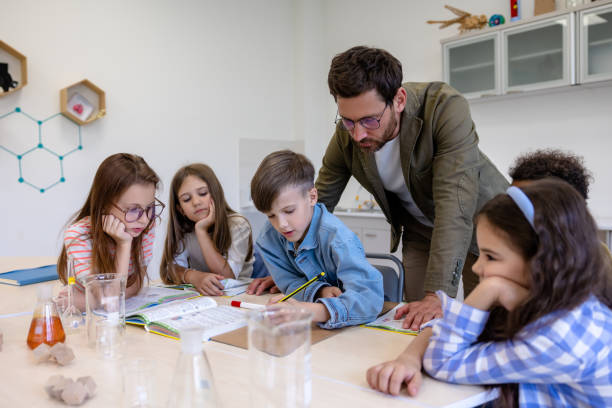 istock Man teacher with kids during chemistry lesson in school classroom. 1724057621