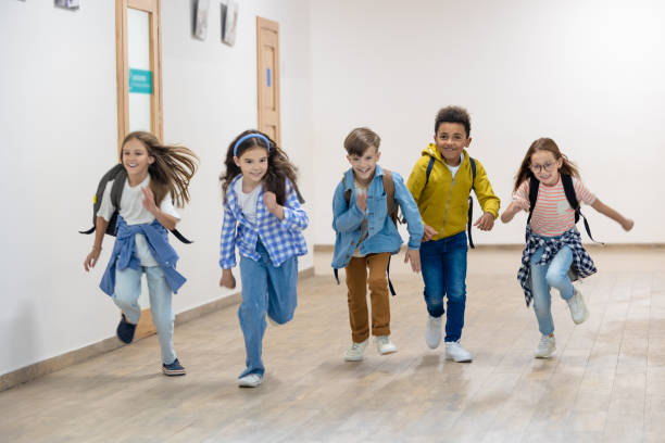 istock Group of elementary school kids running in school corridor. 1724057836