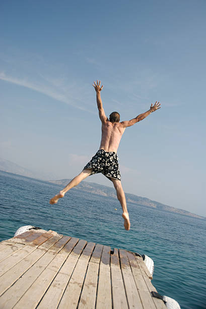 istock Young Man Making Jump for Joy From Dock into Water 172405885