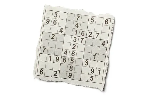 "Torn piece of newspaper Sudoku puzzle, isolated on white background."