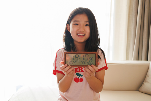 Little girl holding electronic clock