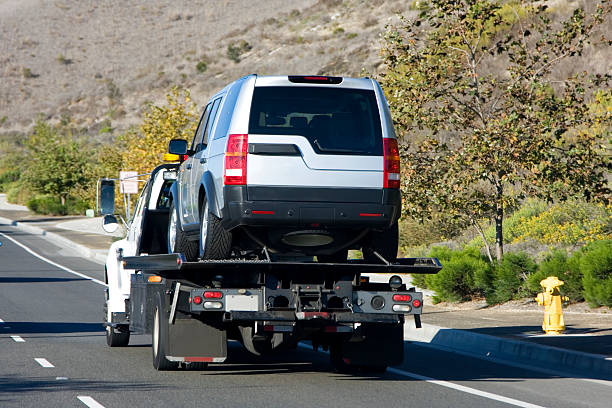tow truck A tow truck towing a silver suv. towing photos stock pictures, royalty-free photos & images