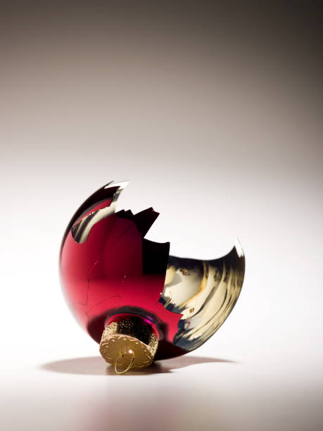 Broken red Christmas ornament on white backdrop stock photo