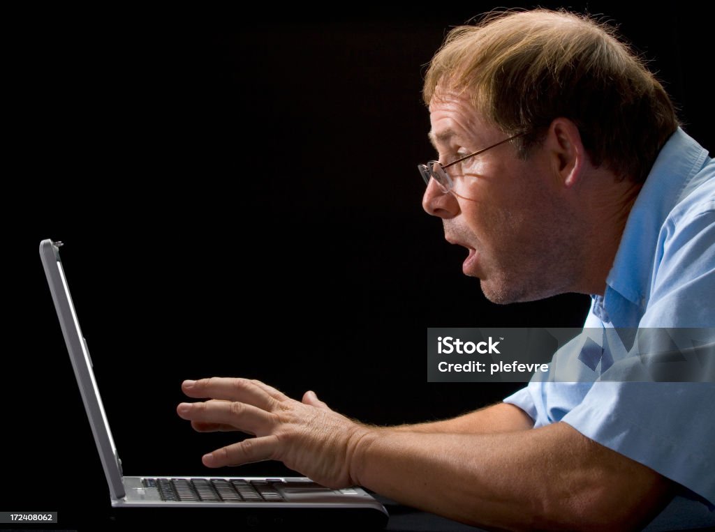 What did I do? "Haggard, unshaven, middle-aged computer user reacts to what he sees on his laptop screen" Adult Stock Photo