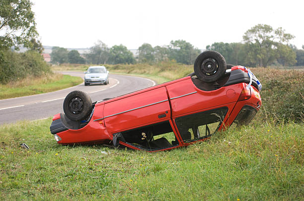 istock Red overturned car in grass by road 172408581
