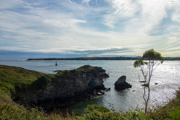 istock Scenic Coastline View: Lighthouse on Horizon Under Blue Sky 1724086292