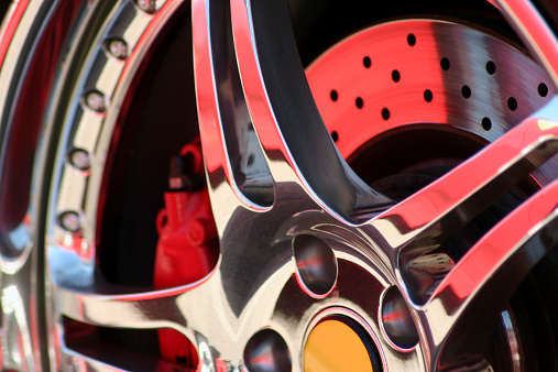 A close up shot of a chrome exotic car rim.