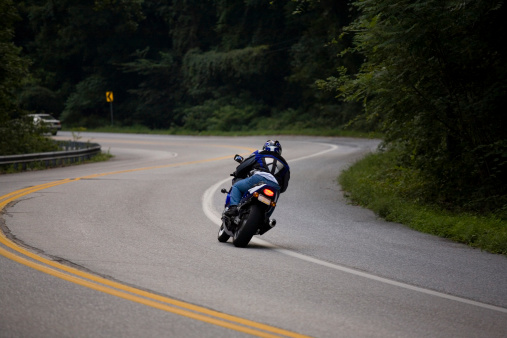 Modern sport bike rider heading up a hill through some S-Curves. Fun road to ride.