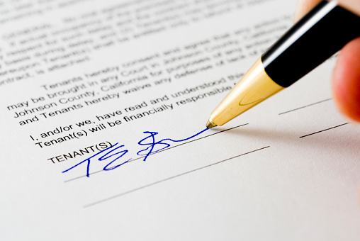A tenant signs a rental agreement.  Signature is fictitious.Click here for related images: