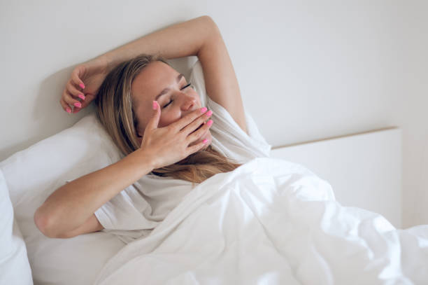 istock Young smiling girl waking up and stretching in bed 1724101071