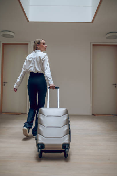 istock Young elegant woman with a suitcase in a hotel hall 1724101951