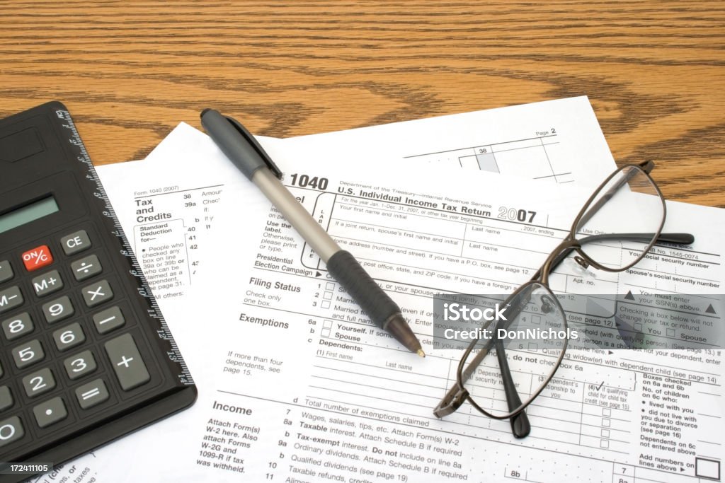 It&#8217;s Tax Time! "Time to do the taxes. US 1040 tax forms for year 2007 on the desk with pen, glasses and calculator.....Please see some similar pictures from my portfolio:" Office Stock Photo