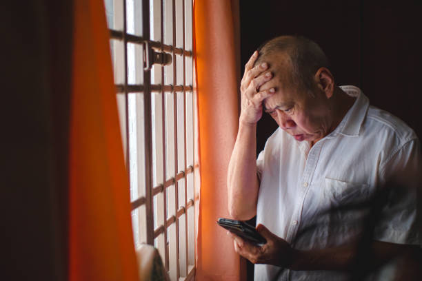 istock Senior Asian man having a hard time, pressing his head while holding phone 1724113425